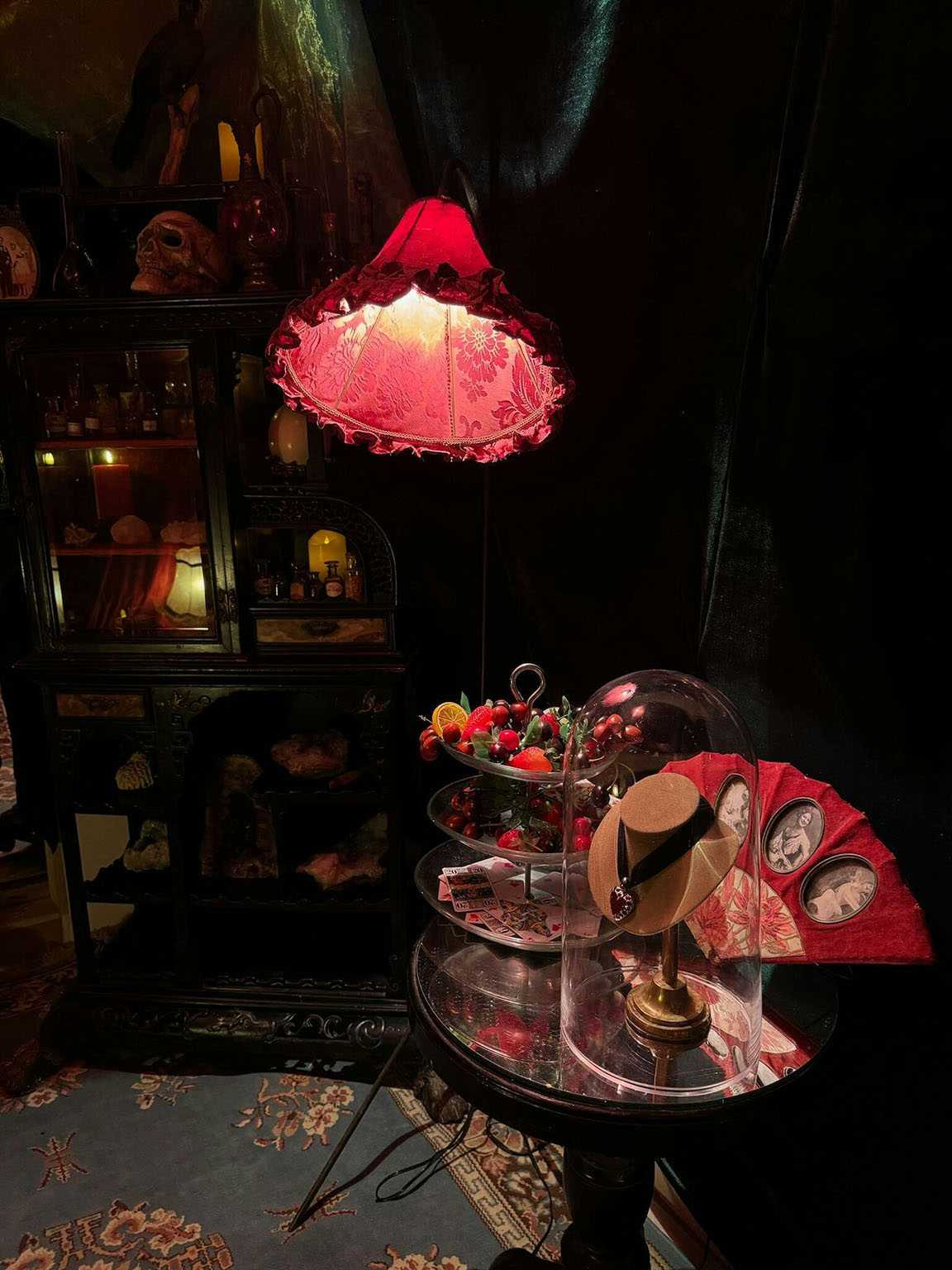 Cabinet of curiosities, skull, red ruffled lamp, cabaret atmosphere.