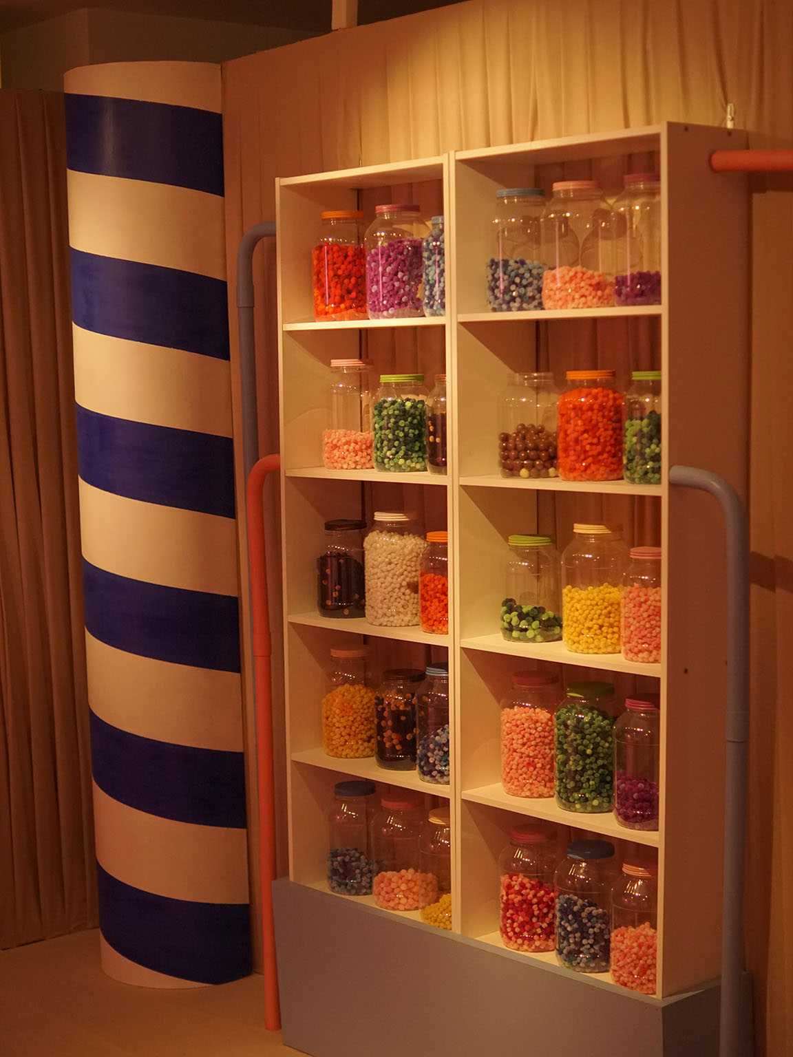 Bocaux de bonbons colorés sur étagères. Décor La Fabrique du Chocolat.