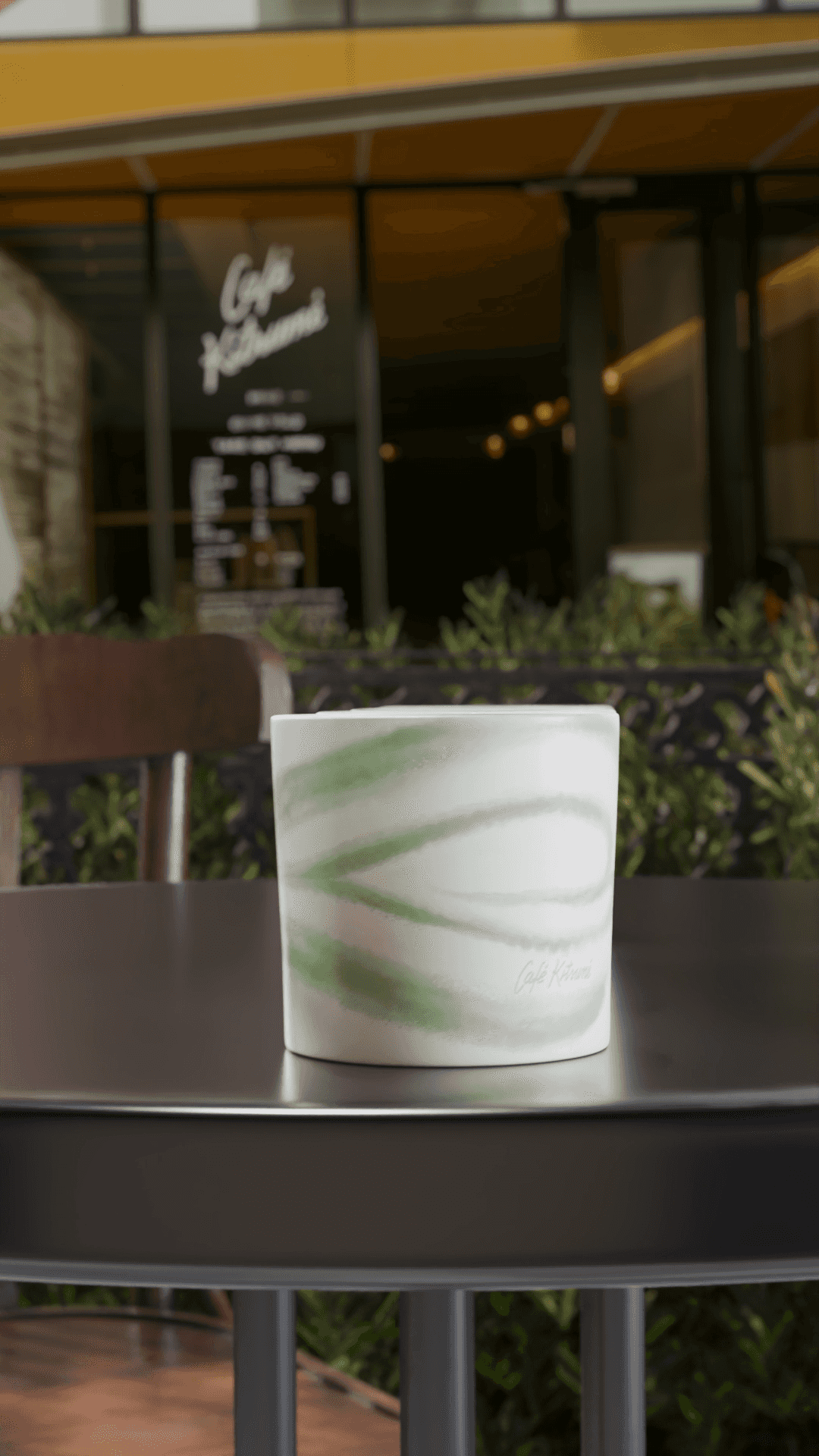 Cafe Kitsune - A kitsune cup on a table with green pattern