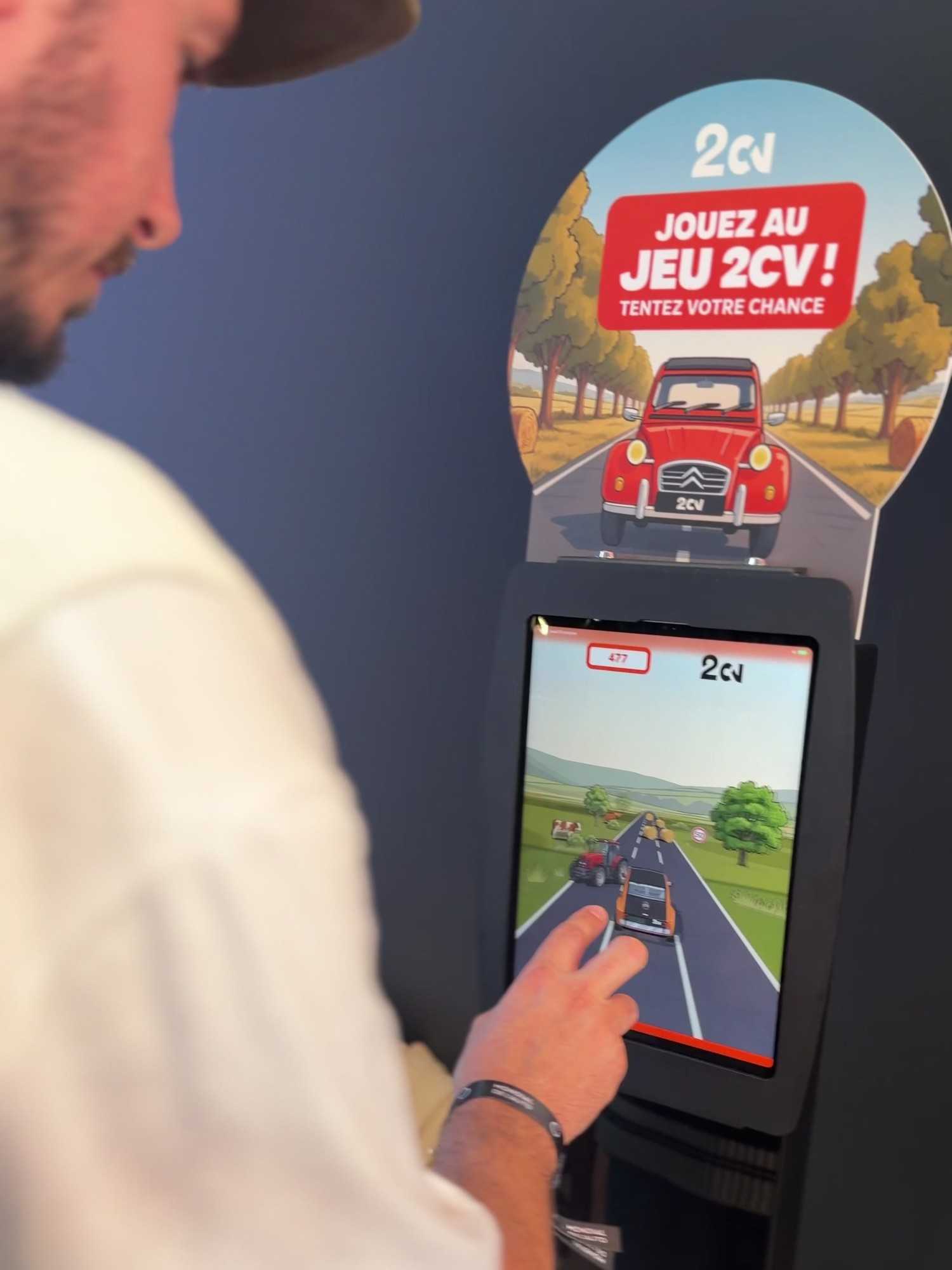 The 2CV game kiosk with its “Play the 2CV game!” topper and a game in progress